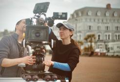 Two filmmakers line up a shot with a film camera