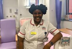 Oluchi smiles towards the camera, she is wearing a student nurse uniform and is pictured in the simulation suites