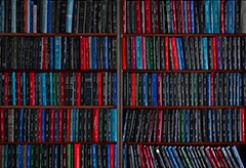 Shelves packed with rows of books arranged vertically, showing spines of various colors.