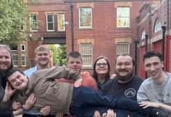 Group of people standing outside of red-brick building 
