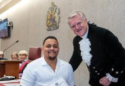 A man receiving an award from a Sherriff in a courtroom