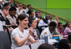 A lady clapping in the crowd at the 2025 SPARC Conference, it is set in one of the lecture halls