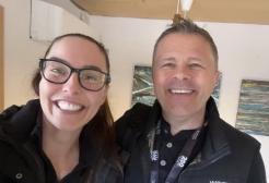 A head and shoulders selfie of a man and a woman smiling at the camera