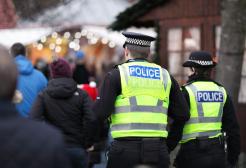 A male and female police officer walking with their backs to the camera