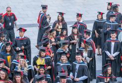 A group of graduating students stood talking after their ceremony