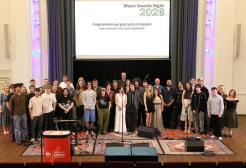 Music students and staff standing together on a stage