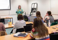 Classroom based learning session with adult students seated at desks with an instructor presenting