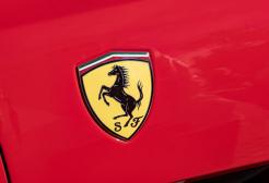 Ferrari logo on red backdrop/car