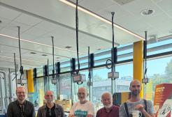 A group of men stood smiling at the camera, one of whom has a prosthetic arm