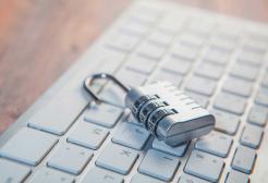 Combination padlock resting on a computer keyboard, representing data protection, privacy and UK GDPR compliance.