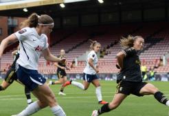 two footballers compete for a football