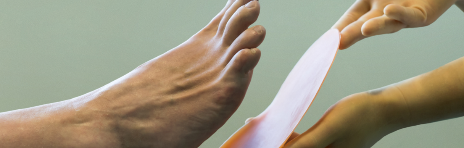 Image of podiatrist's hand near foot 
