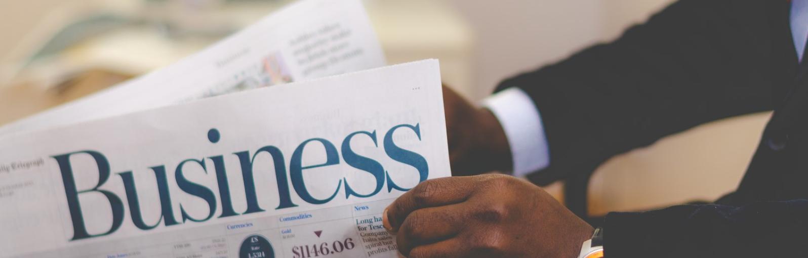 A person reads a business newspaper