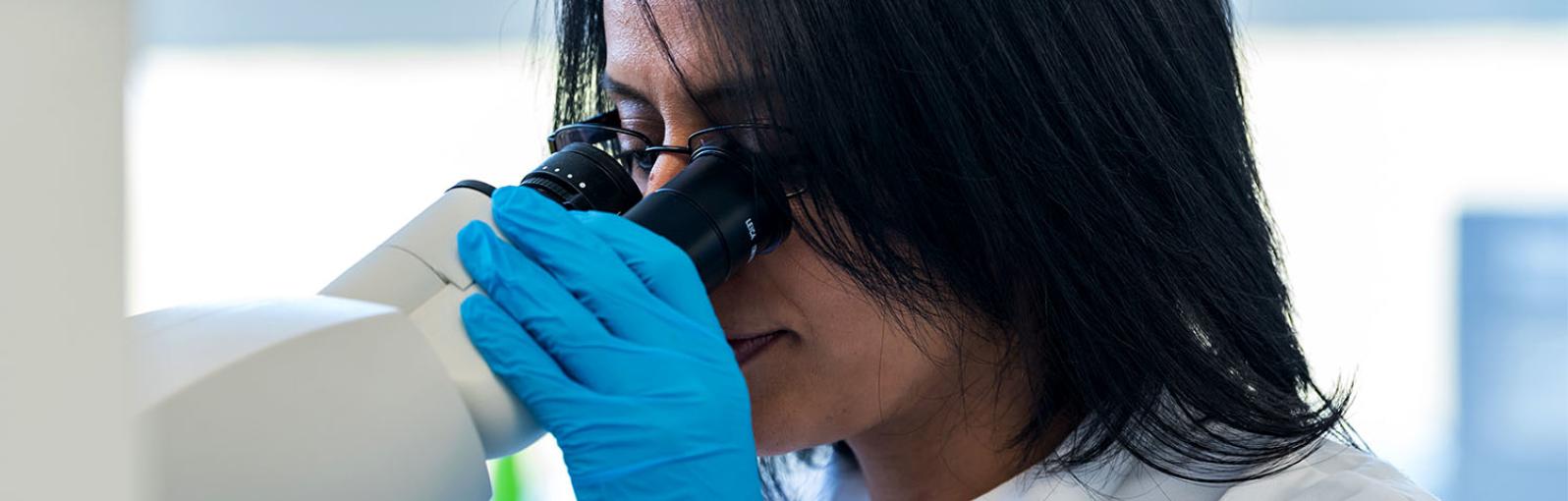 A bioscientist looking through a microscope