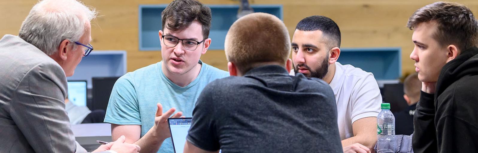 Computer science students talking with tutor
