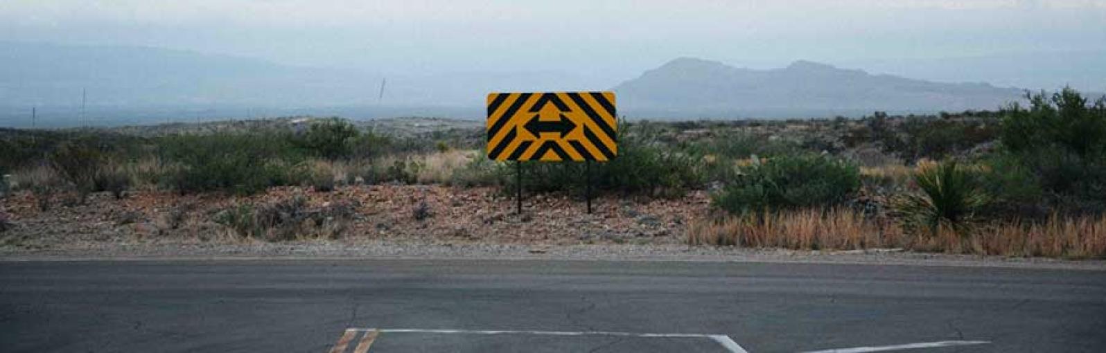 A sign on a roadside pointing in two directions