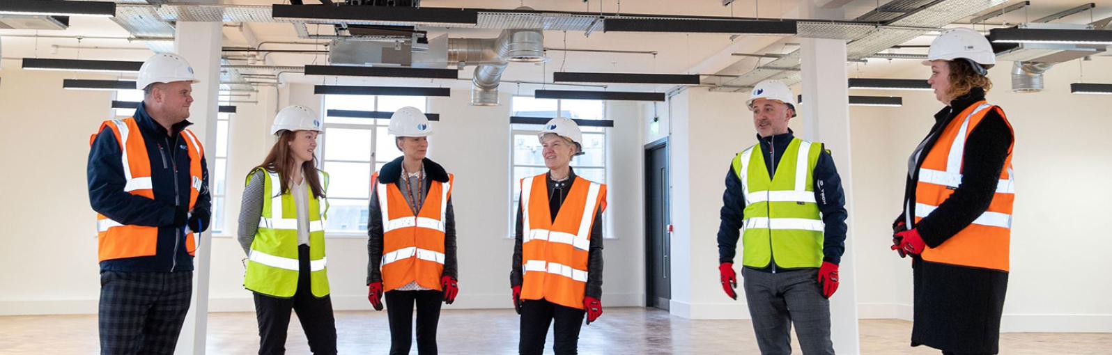 Construction Apprentices with their employers in a new building