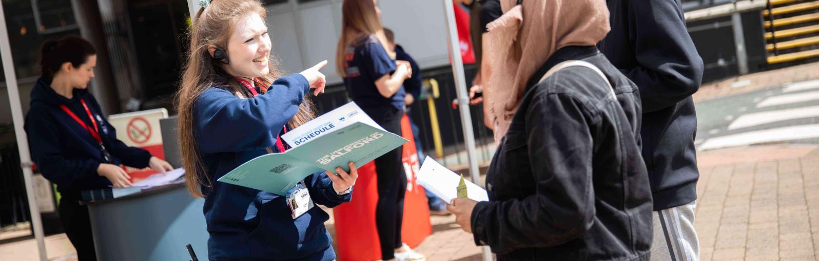 Visitors receiving information booklet on open day 