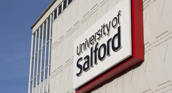 A sign for the University of Salford, located on the side of Maxwell Building