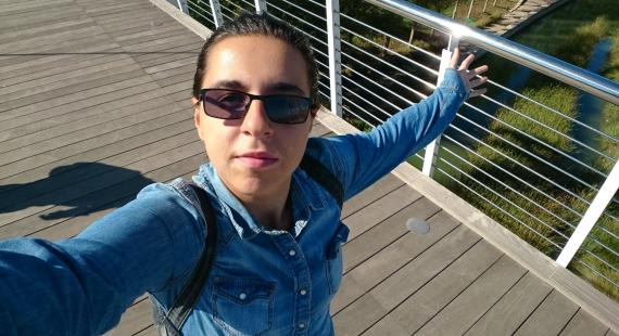 Student taking a selfie on a bridge in the sun in Spain