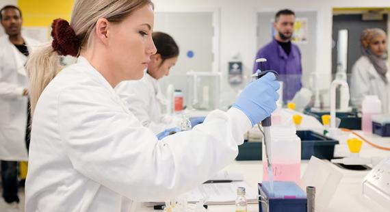 Chemistry student using a pipette in a laboratory