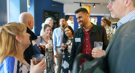 Colleagues in conversation at an alumni event