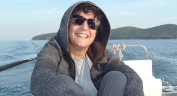 Dr Chrysoula Gubili smiling sitting on a boat in the ocean
