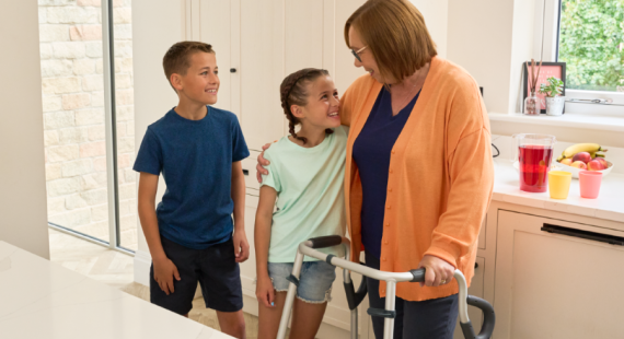 A woman with a Walk Safe walking frame talking to her grandchildren