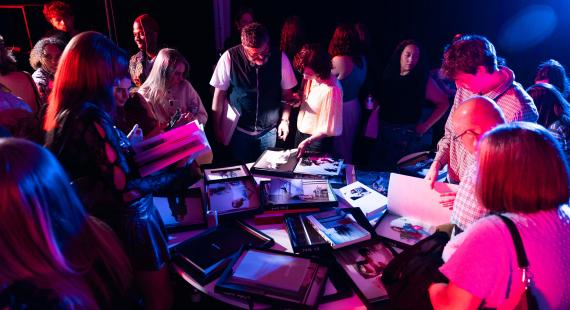 Visitors looking through magazines at student exhibition 