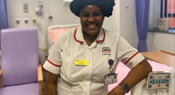 Oluchi smiles towards the camera, she is wearing a student nurse uniform and is pictured in the simulation suites