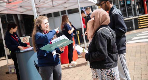 Visitors receiving information booklet on open day 