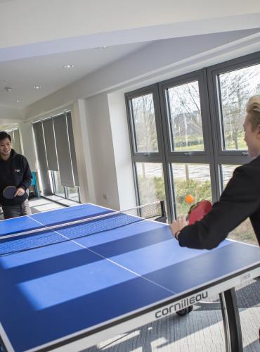 Students playing table tennis in Peel Park Quarter student accommodation