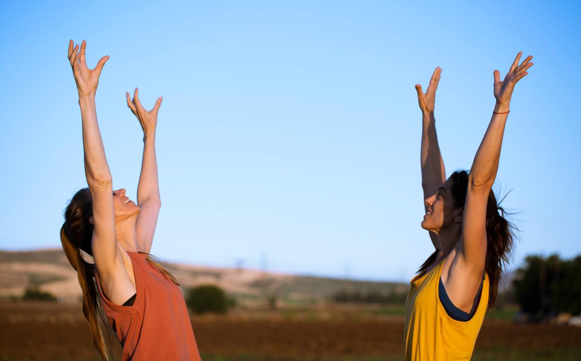 Image shows two women putting their hands in the air
