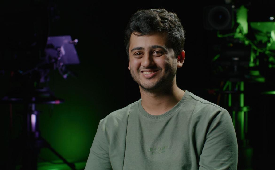 A man in a TV studio smiling