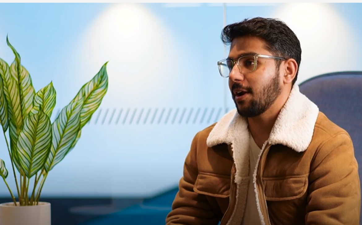 A student sat on a chair talking to camera