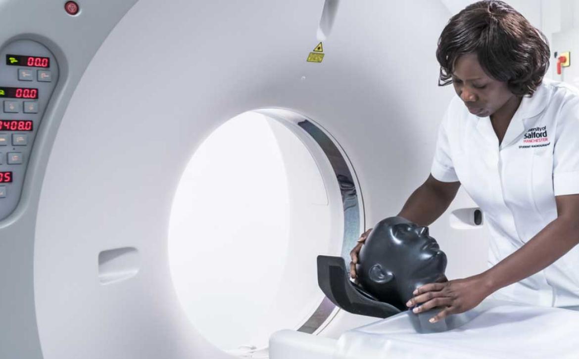 Student using radiography scanning equipment with test dummy