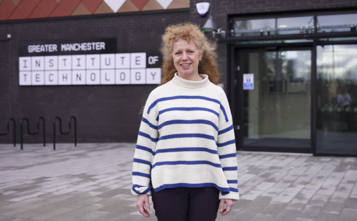 Jo Purves standing outside the Greater Manchester Institute of Technology building