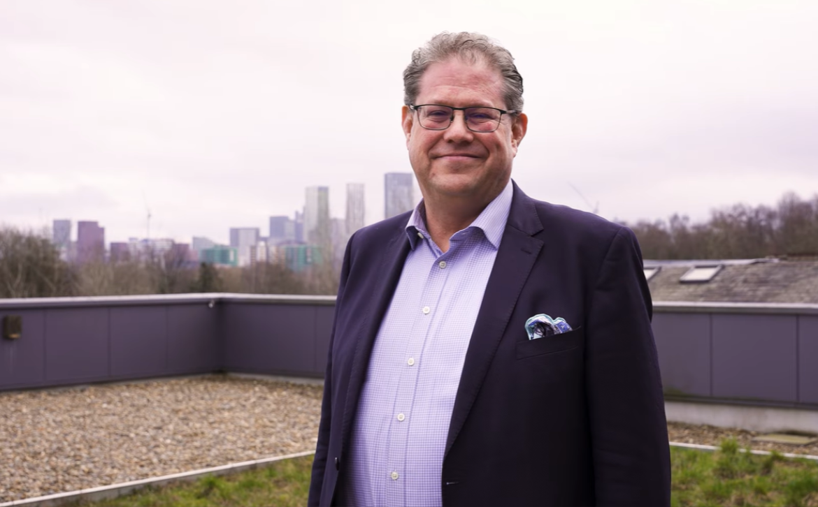 Simon Green standing on a rooftop, on a University building 